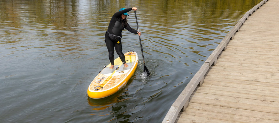 Woman demonstrating intermediate SUP techniques on a stand up paddleboard