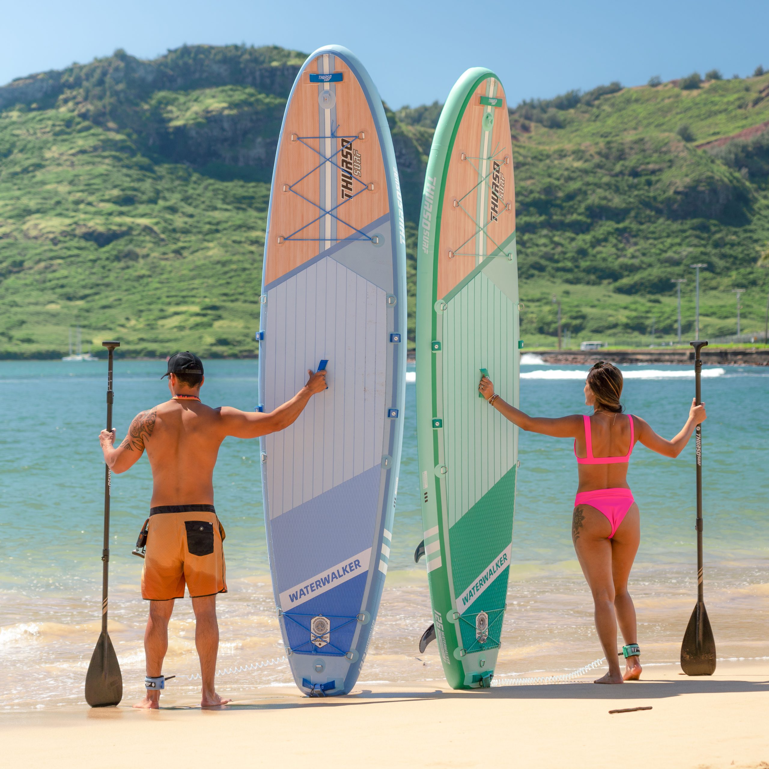 man and woman standing with waterwalker turquoise paddle boards