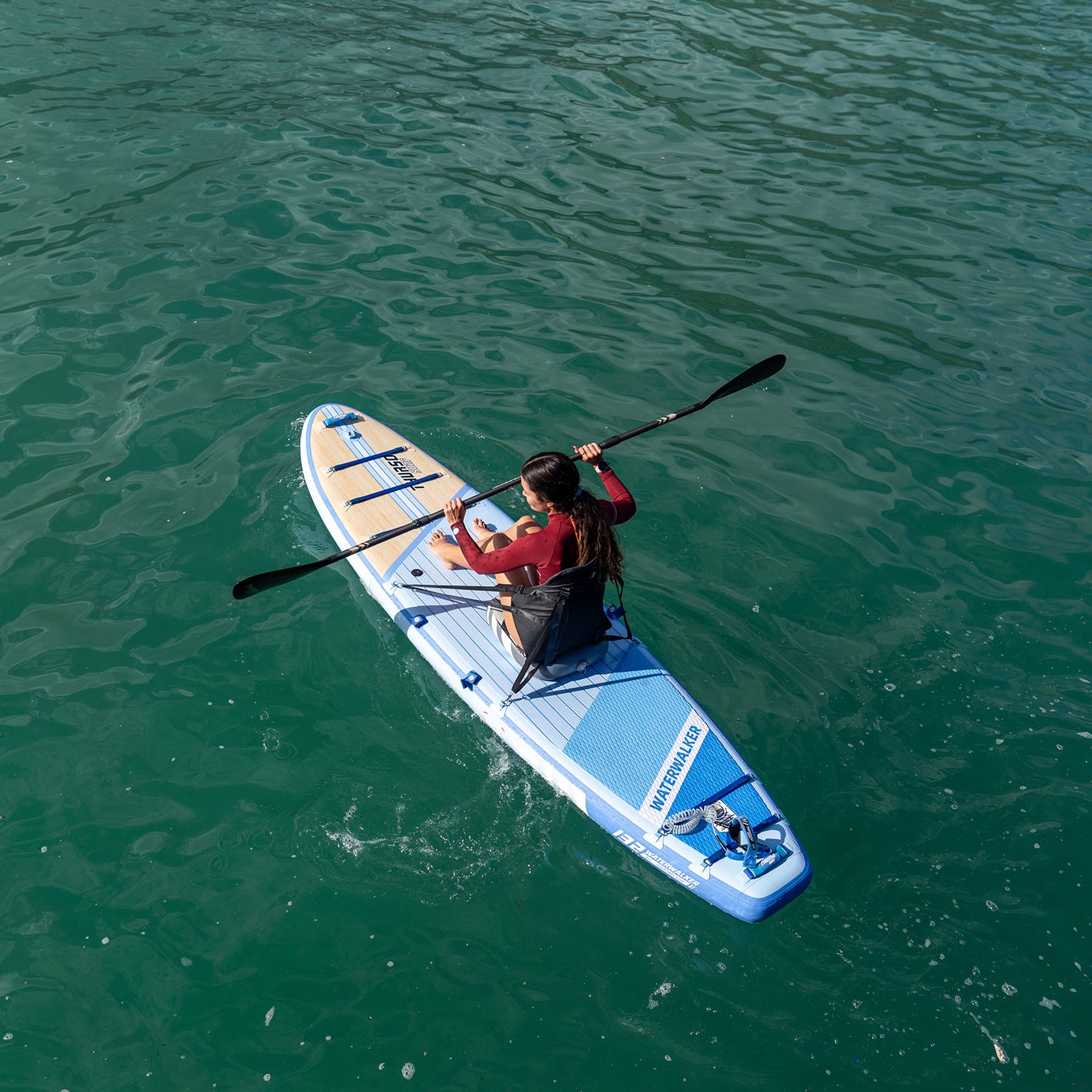 Person paddleboarding on a calm body of water with dusk color sup