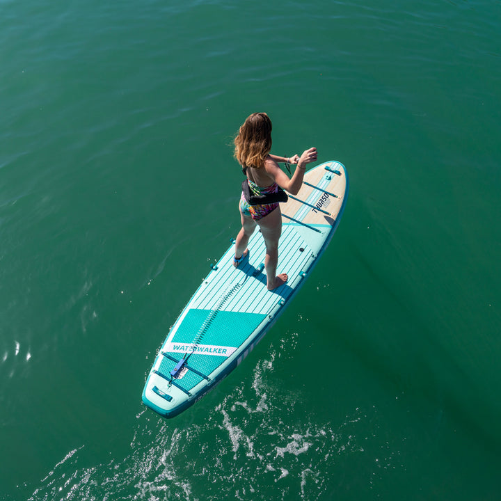 Person paddleboarding on a clear blue lake with thurso surf turquoise sup